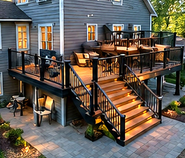 Multi-level composite deck with under-rail lighting at dusk, Connecticut carpentry project
