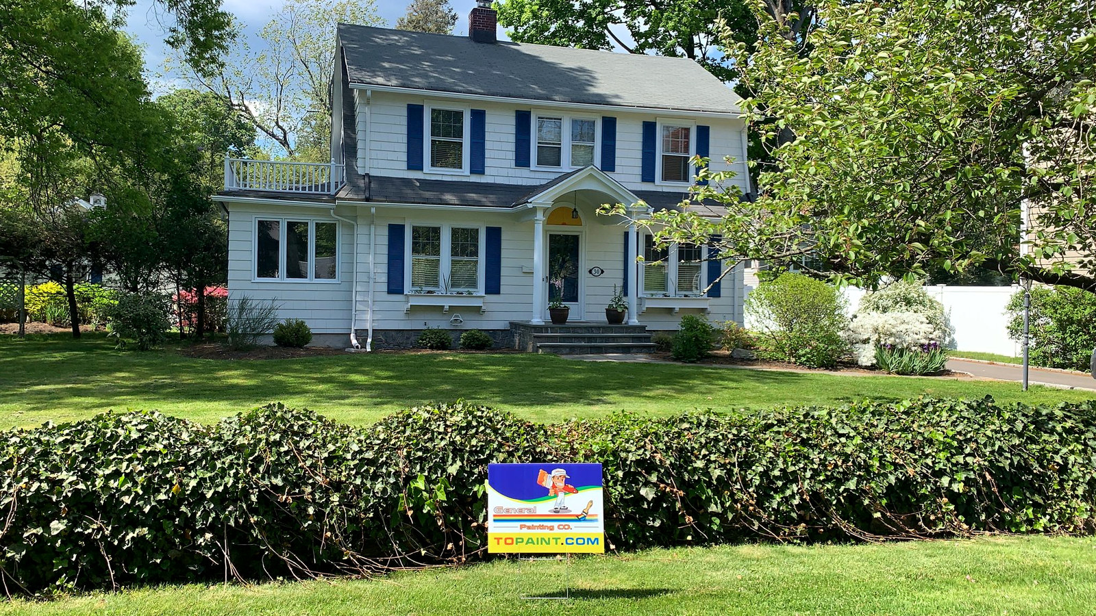 Classic Connecticut colonial with white siding, blue shutters and red door