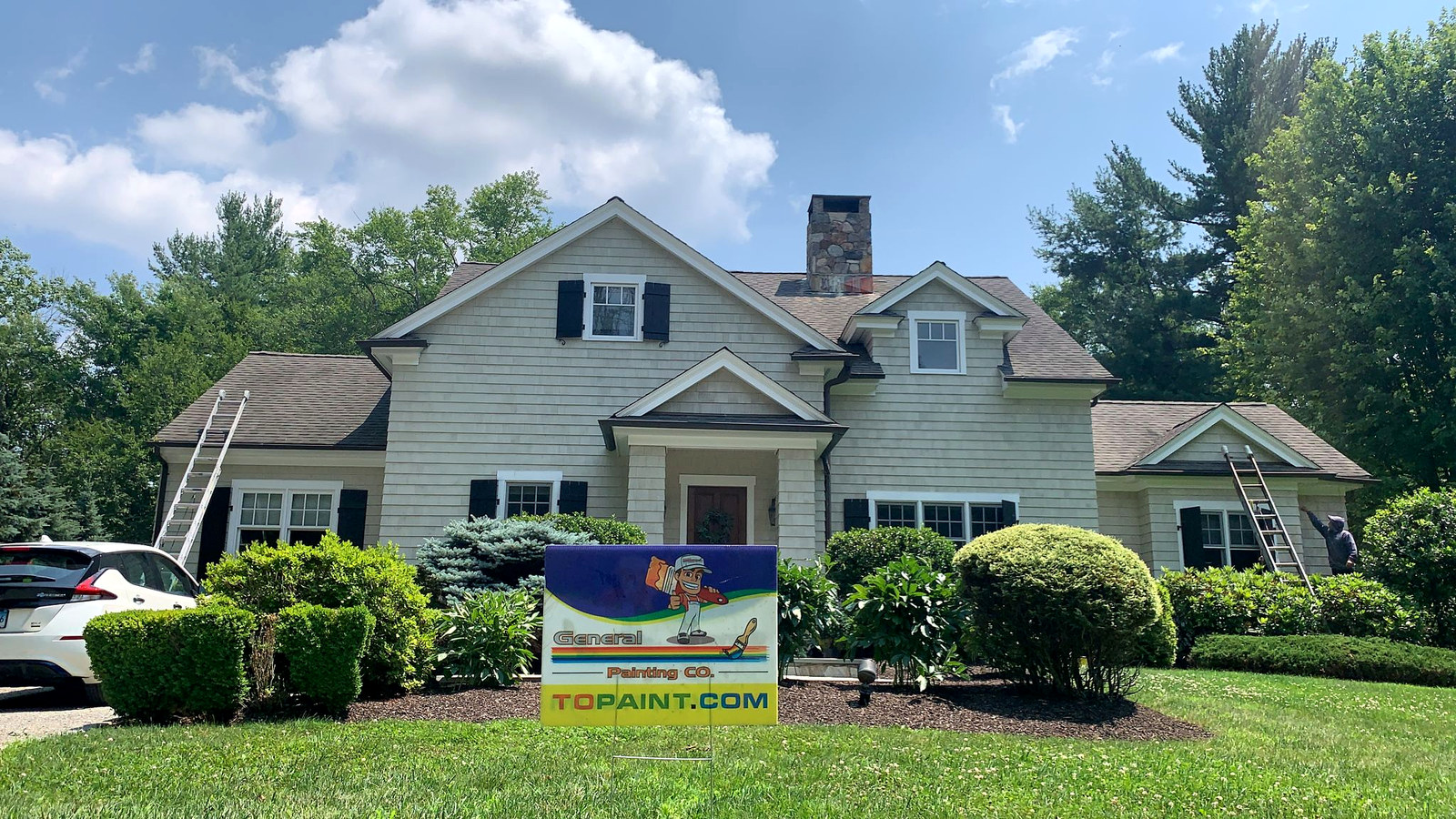 Sage green cedar shingle home with white trim