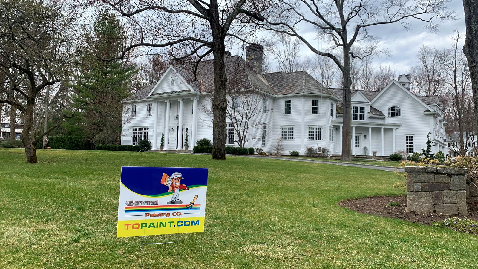 White colonial mansion with manicured lawn