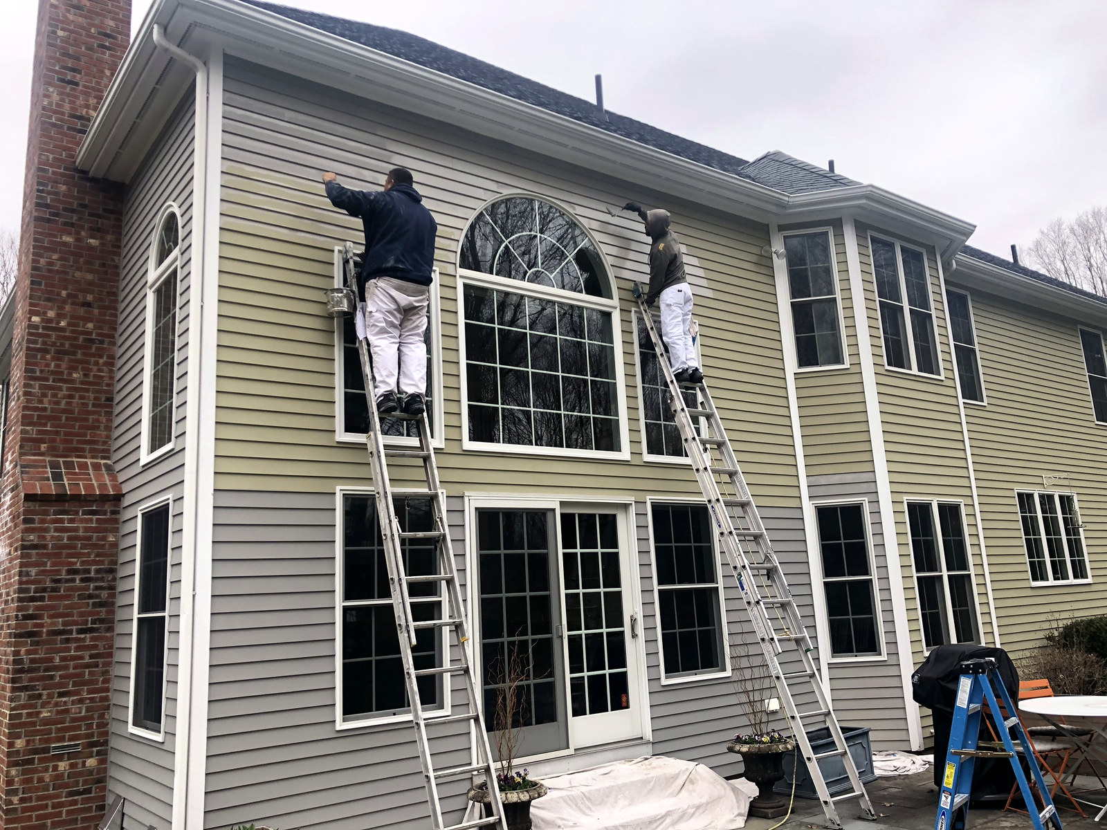 Two professional painters on ladders at a Palladian-window home in CT